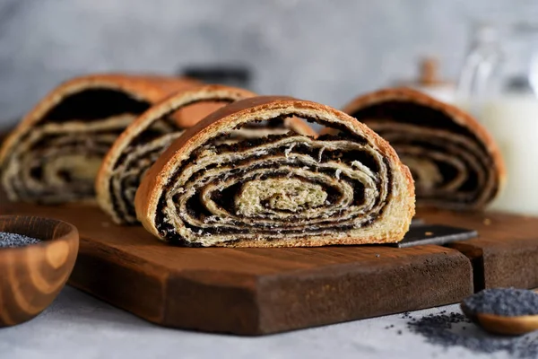 Bun com sementes de papoila e leite em um fundo de concreto — Fotografia de Stock