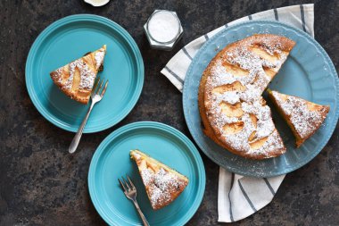Charlotte - a classic pie with apples on a concrete background.