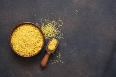 Beton arka planda, tabakta makarna. Üst görünüm kopyalama alanı.