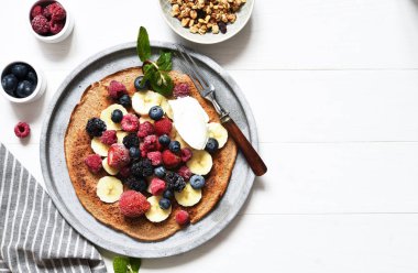 Kahvaltıda böğürtlenli krep ve yoğurt. Kahvaltı mutfak masasının üstünde..