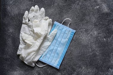 Beton bir arka planda eldiven ve maske. Tıbbi aksesuarlar. Coronoviris koruması..