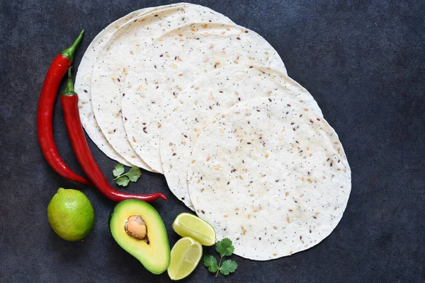 Corn tortilla for making tacos with chili and avocado. Ingredients for cooking quesadillas.