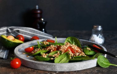 Ispanaklı salata, domates ve beton tabakta buğday fideleri..