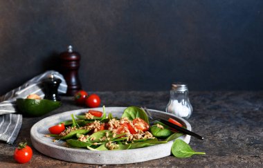Ispanaklı salata, domates ve beton tabakta buğday fideleri..
