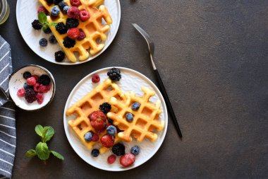 Viyana waffleları koyu beton arka planda böğürtlen ile. Yukarıdan görüntüle.