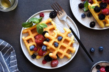 Viyana waffleları koyu beton arka planda böğürtlen ile. Yukarıdan görüntüle.