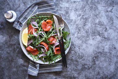 Mutfak masasında roka ve somon salatası. Metin için yeri olan üst görünüm.