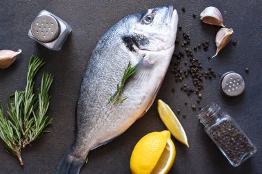 Pişirme malzemeleri taze dorado, limon, biberiye ve baharattır. Yukarıdan görüntüle.