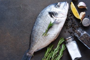 Pişirme malzemeleri taze dorado, limon, biberiye ve baharattır. Yukarıdan görüntüle.