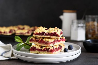 Koyu arkaplanda vişneli ve yabanmersinli rendelenmiş turta. Yatay odak.