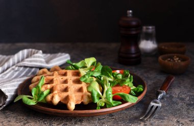 Mısır salatası ve tomanlı peynirli waffle. Beton zeminde sağlıklı bir kahvaltı..