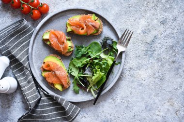 Somon balıklı tost ve beton tabakta salata, üst manzara. Kahvaltı..