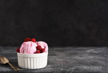 Beton arka planda kasede ahududu dondurması. Yatay odak.