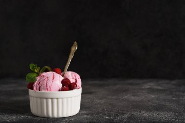 Beton arka planda kasede ahududu dondurması. Yatay odak.