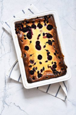 Mutfak masasında çimento üzerine ricotta ve dutlu cheesecake..