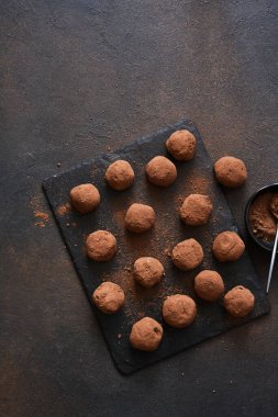 Koyu arkaplana karşı taş bir tahtanın üzerinde çikolatalı mantar. Yukarıdan görüntüle.