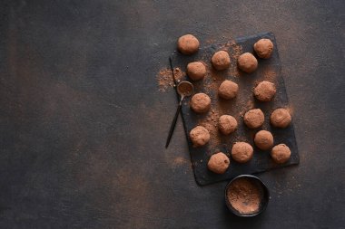 Koyu arkaplana karşı taş bir tahtanın üzerinde çikolatalı mantar. Yukarıdan görüntüle.