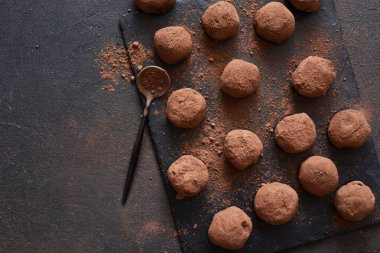Koyu arkaplana karşı taş bir tahtanın üzerinde çikolatalı mantar. Yukarıdan görüntüle.