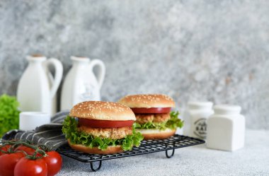 Beton bir masada soslu ve sebzeli hamburger. Fast food.