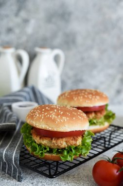 Beton bir masada soslu ve sebzeli hamburger. Fast food.