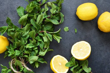 Siyah arka planda limon ve nane karışımı. Limonata malzemesi..