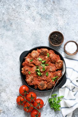 Beton zeminde domates soslu köfteli kızartma tavası..