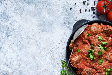 Beton zeminde domates soslu köfteli kızartma tavası..