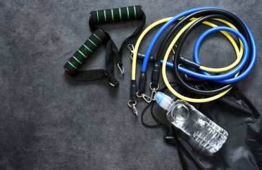 Spor aksesuarları. Siyah arka planda su ve karabinalı bir genişletici. Fitness.