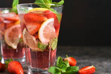 Koyu beton arka planda çilekli limonata ve nane şekeri. Yaz soğuk içeceği.
