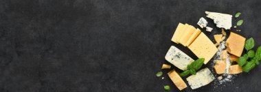Peynir seti: Brie peyniri, mavi peynir, parmesan peyniri ve siyah beton kaplama fesleğen. Yukarıdan görüntüle.