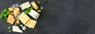 Peynir seti: Brie peyniri, mavi peynir, parmesan peyniri ve siyah beton kaplama fesleğen. Yukarıdan görüntüle.