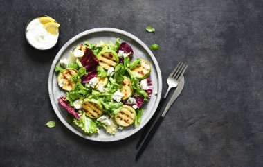 Salata ile ızgara kabağı ve sosu siyah arka planda karıştır. Üst manzara ve fotokopi alanı..