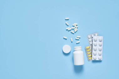 Mavi arka planda farklı haplar. Sağlık hizmetleri. Düzgünce.