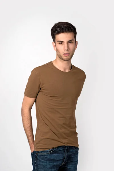 Ο νεαρός άνδρας σε ένα πουκάμισο και τζιν φαίνεται στην κάμερα. — Φωτογραφία Αρχείου