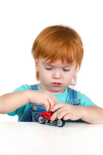 Дитина з рудим волоссям грає з іграшкою — стокове фото