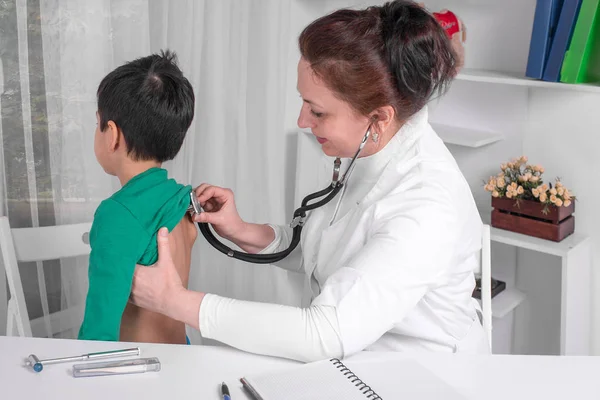 El médico examina al niño enfermo en un consultorio — Foto de Stock