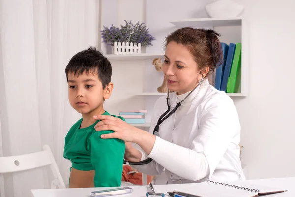 El médico examina al niño enfermo en un consultorio — Foto de Stock