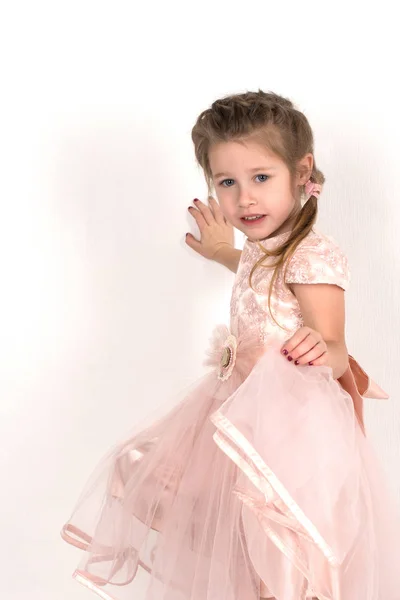 A menina em um vestido de bola rosa e com olhos azuis está em um wal — Fotografia de Stock