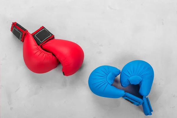 Guantes de combate azules y rojos sobre un fondo de hormigón — Foto de Stock