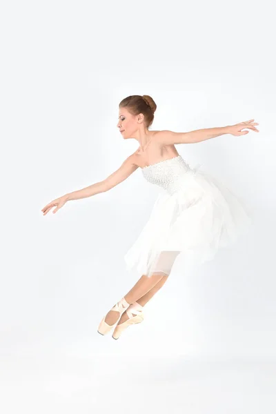 A bailarina em pointes e um vestido dança em um contexto branco — Fotografia de Stock