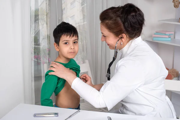 El pediatra médico examina al niño enfermo en una clínica — Foto de Stock