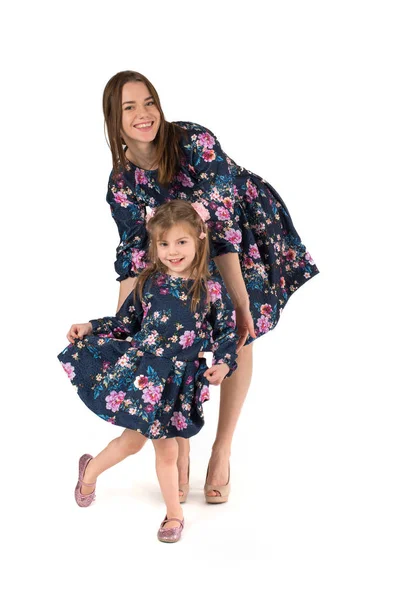 母亲与女儿在相同的礼服跳舞和微笑 — 图库照片