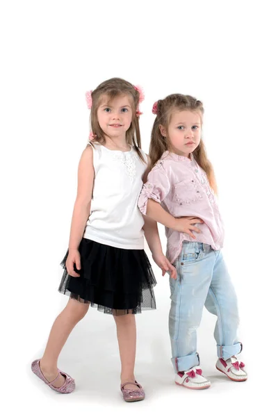 Twee meisjes de blonde in een shirt en spijkerbroek op wite achtergrond — Stockfoto