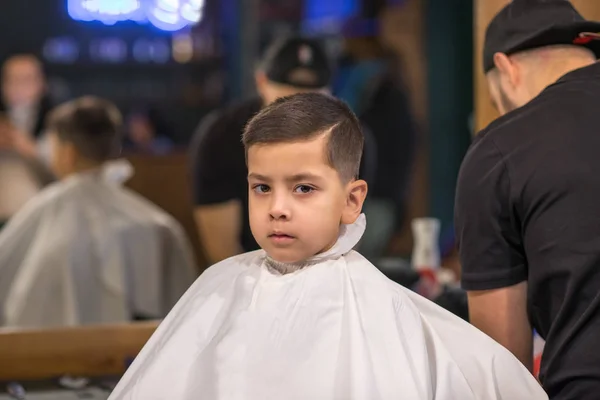Мальчика стригут в парикмахерской — стоковое фото