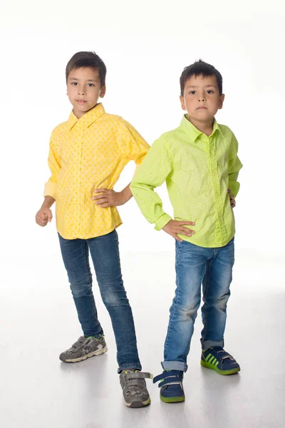 Twee jongens in een shirt en spijkerbroek staan op witte achtergrond in de studio — Stockfoto