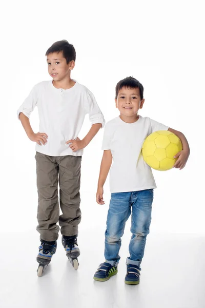 Dva chlapce jezdit na kolečkových bruslích a soccerball. — Stock fotografie