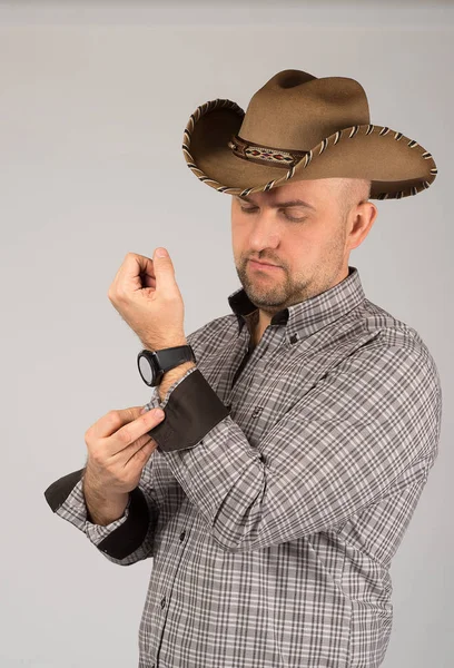 O retrato do homem com um chapéu de cowboy em fundo cinza no estúdio — Fotografia de Stock