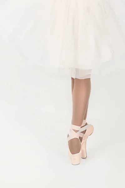 Jambes de la ballerine en pointes et une robe blanche isolé o — Photo