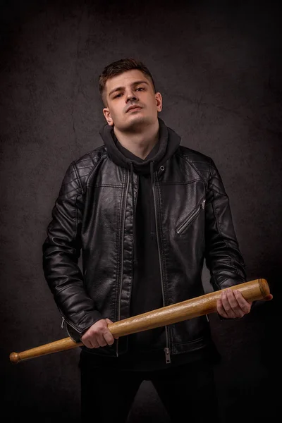 Молодий чоловік шкіряний піджак на чорній стіні в бойовій позі w — стокове фото