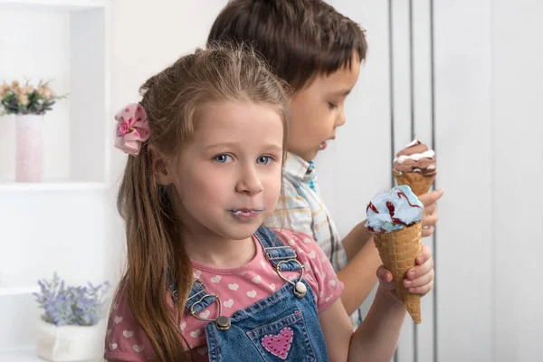 El niño y la niña alegremente comer helado en pistola de obleas — Foto de Stock